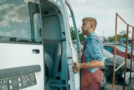 male-repairman-removes-the-door-on-car-scrapyard-2024-11-27-11-32-31-utc.jpg