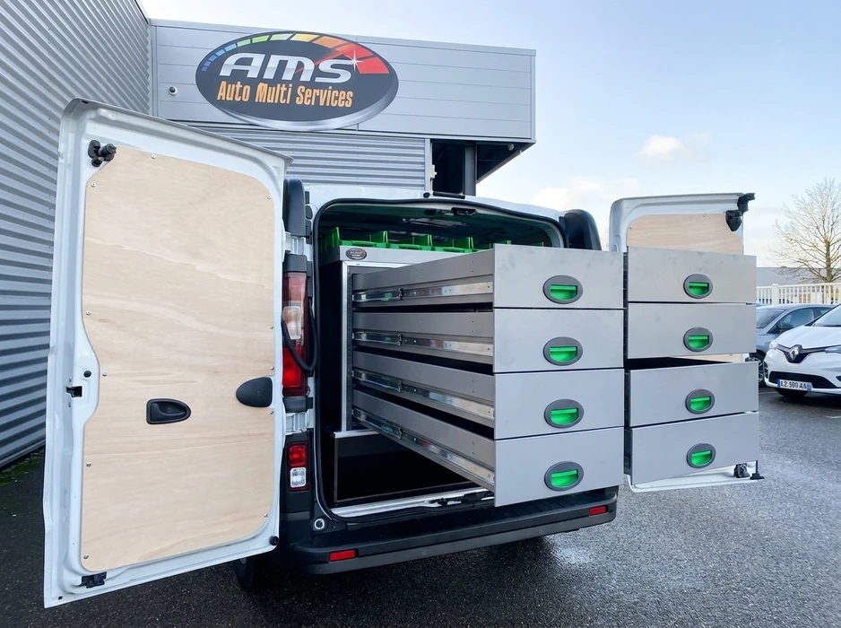 Aménagement intérieur de van utilitaire, portes arrière ouvertes, dans un parking de garage