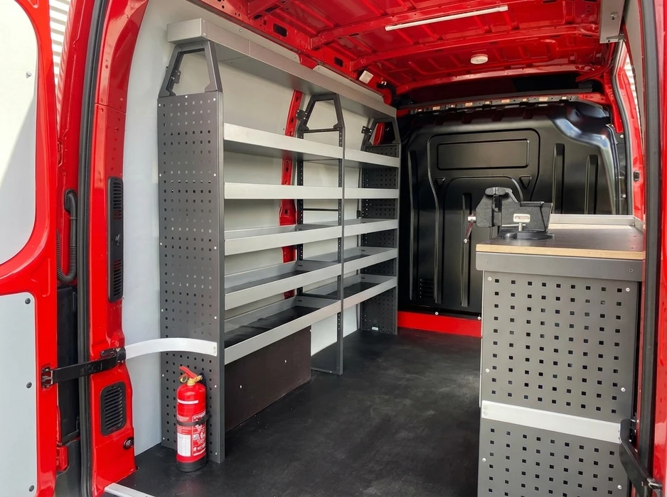 Intérieur aménagé d'un fourgon utilitaire rouge, vue depuis les portes arrière ouvertes