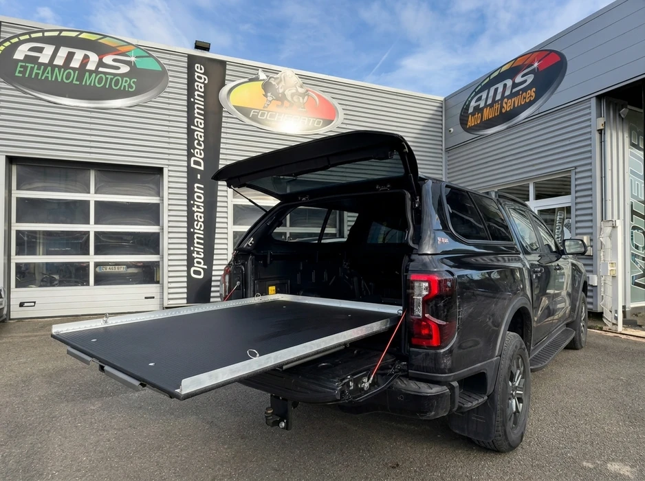 Pickup truck noir Ford Ranger devant un garage AMS Auto Multi Services