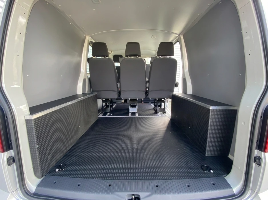 Intérieur cargo d'un van utilitaire aménagé, vue depuis les portes arrières ouvertes